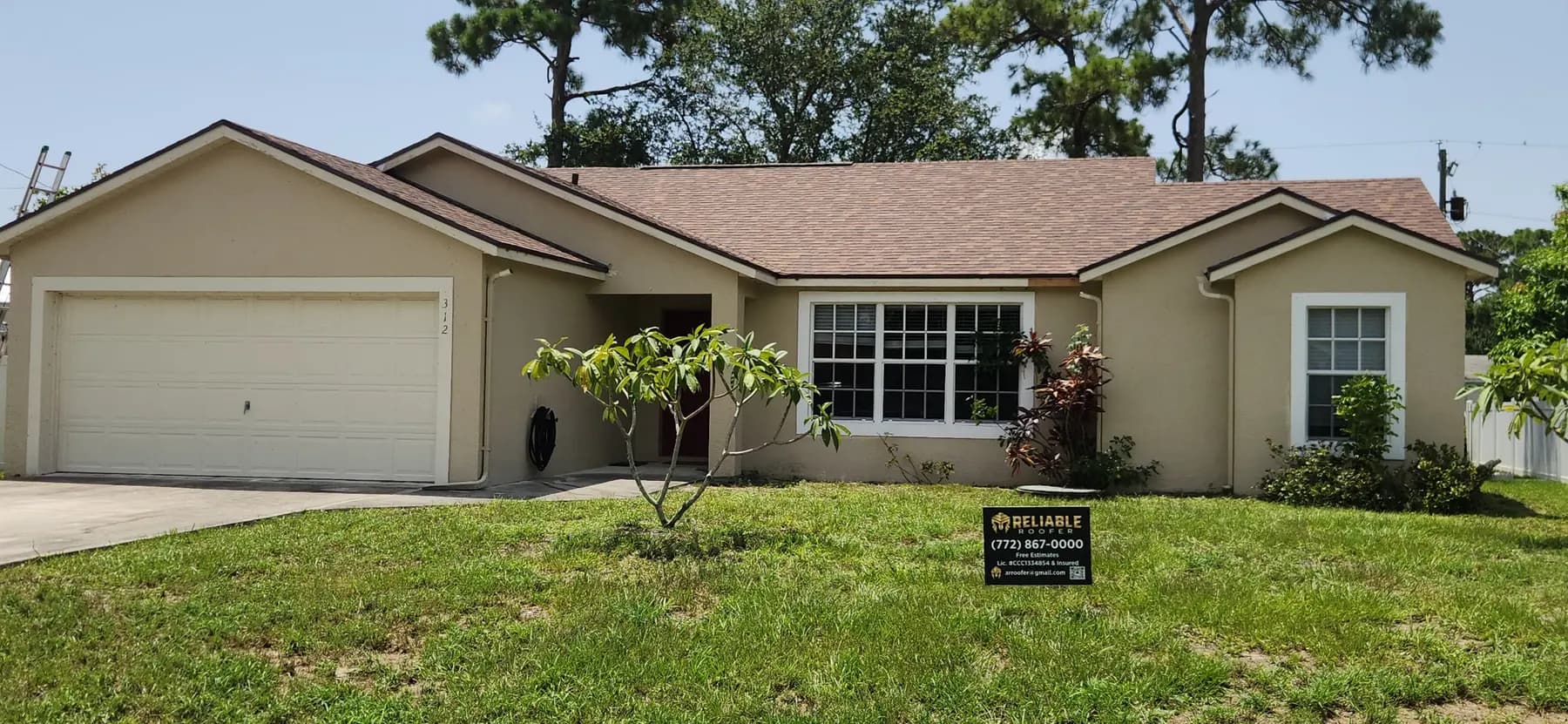 Finished brown shingle roof with a Reliable Roofer yard sign on the lawn