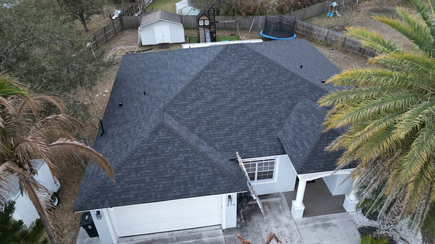 Dark architectural shingle roof on a white single-story home