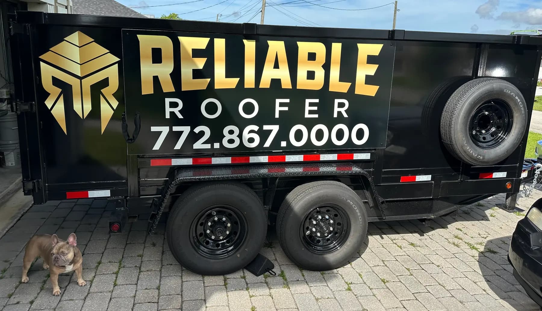 Reliable Roofer branded dump trailer at a job site