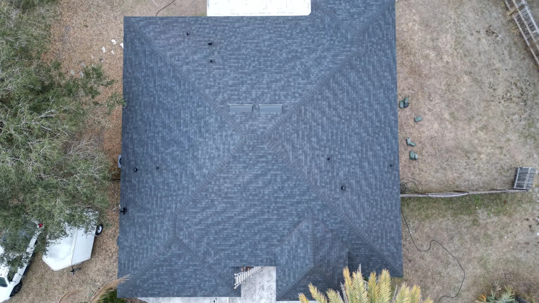 Top-down charcoal architectural shingle hip roof after installation
