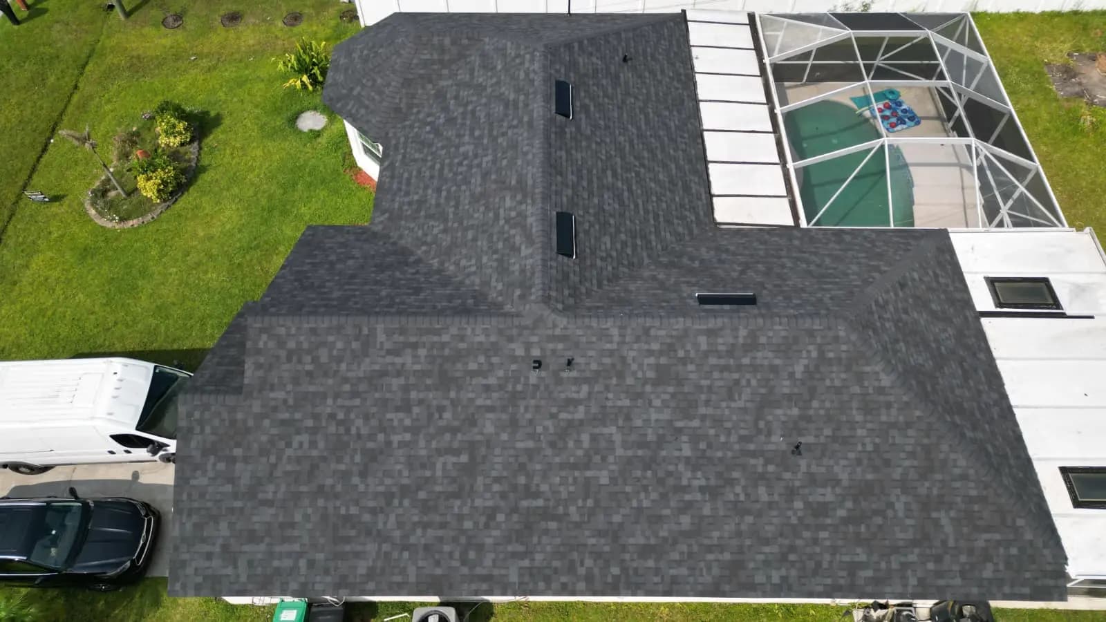 Dark architectural shingle roof beside a screened enclosure